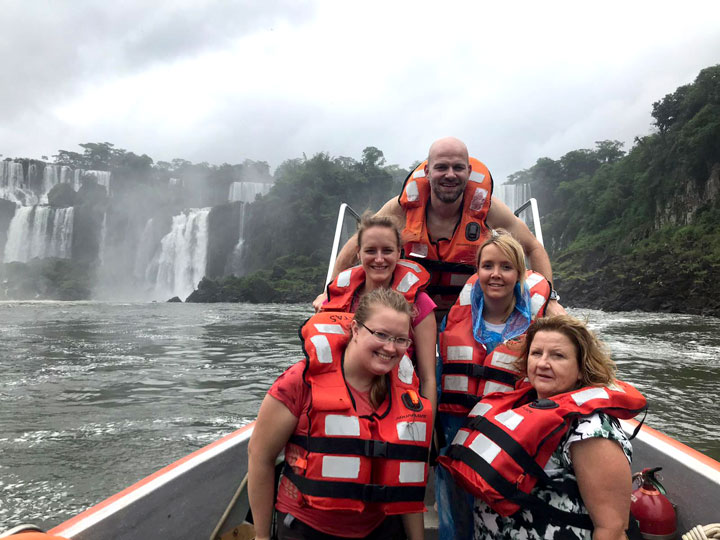Cuatro mujeres y un hombre en un bote navegan en el rió Iguazú